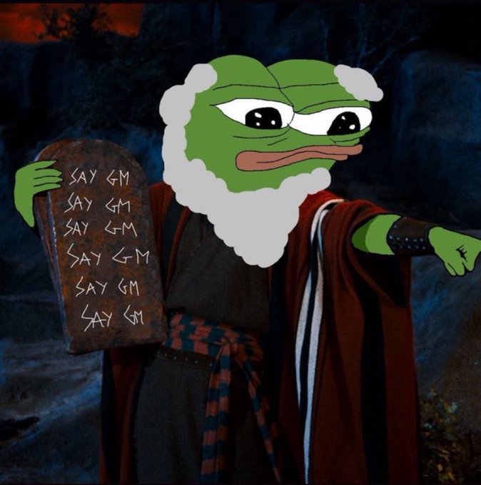 Meme image of a figure in biblical robes with a Pepe the Frog face holding stone tablets inscribed with 'SAY GM' repeated multiple times.