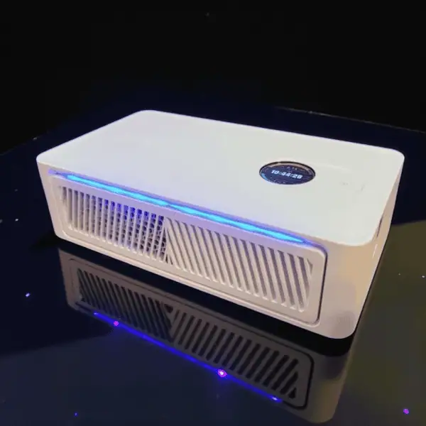 A white rectangular electronic device with a digital display, vented grilles, and blue LED lighting, resting on a reflective black surface.