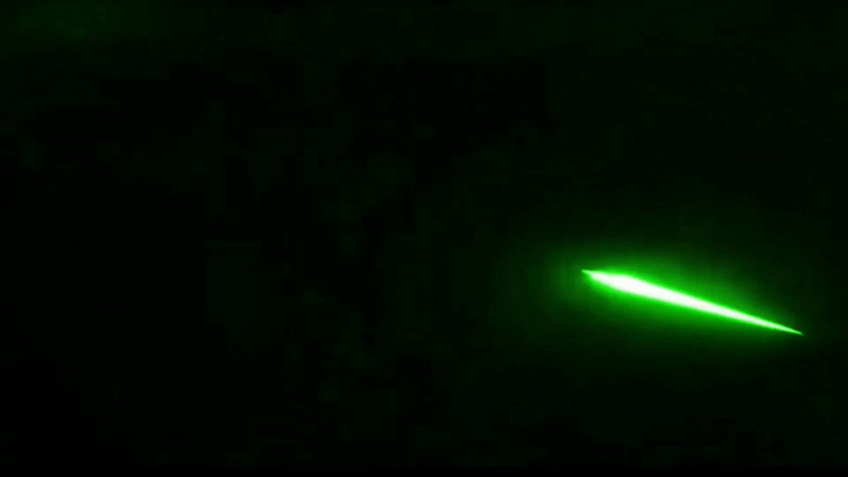The image shows a green light or beam of light, possibly from a laser pointer, shining through a dark background. The focus of the image seems to be on this bright green light, with no other objects or text present. The caption "POV: candle printing the second you sell" is written in white at the bottom right corner of the photo. This could potentially be an advertisement for a product or service related to candles, as suggested by the phrase "candle printing".