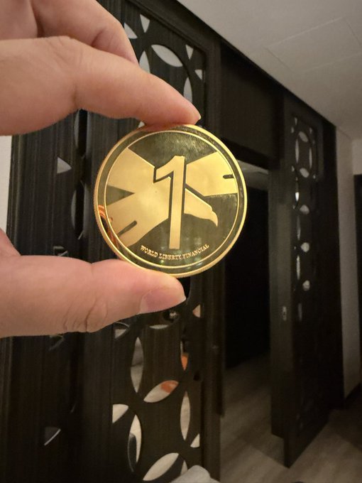 A hand holds a gold token featuring a "1" and the text "BUREAU OF ENGRAVING AND PRINTING," symbolizing USD, while the post promotes earning up to 8.5% APR with USD1 on Binance Earn.