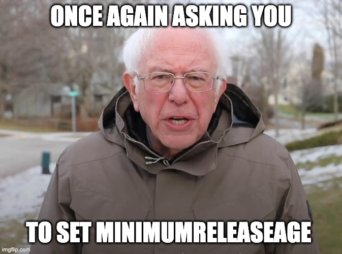The image shows Bernie Sanders wearing a winter coat outdoors with the caption "ONCE AGAIN ASKING YOU TO SET MINIMUMRELEASEAGE," humorously framing it as a personal plea to developers to configure this release setting rather than letting it default to an immediate release.