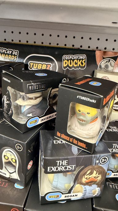 Store display of TUBBZ cosplaying ducks collectibles in boxes, featuring characters from The Exorcist (Regan) and The Invisible Man, priced around $24.