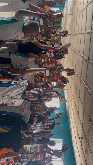 A group of smiling students wearing white school uniforms hold up colorful flyers and branded notebooks featuring BNB Chain and Web3 educational materials during a classroom session introducing them to blockchain technology. The engaged learners display their handouts enthusiastically, reflecting the post's message about bringing crypto education directly to students.