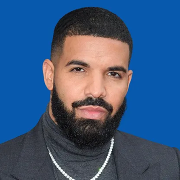 Drake poses in a portrait with a neutral expression against a blue background, wearing a gray blazer over a black turtleneck with a silver chain necklace. The image accompanies news of Drake's $1.5 million USDT bet on Argentina winning the FIFA World Cup final against Spain.