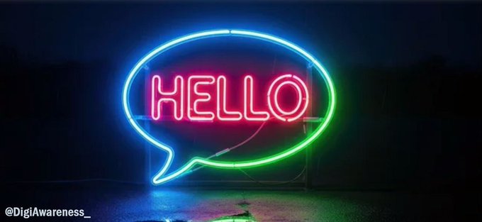 A neon sign shaped like a speech bubble with a blue-to-green gradient border displays the word "HELLO" in pink lettering against a dark background, with the watermark "@DigiAwareness_" in the bottom left corner.