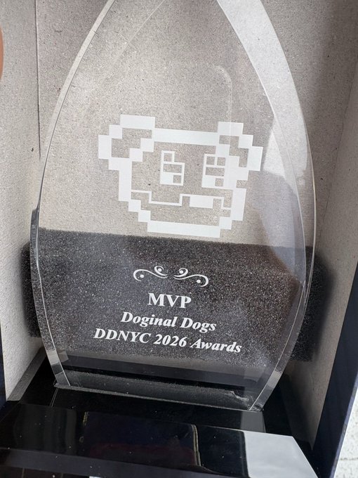A glass award plaque reads 'MVP, Doginal Dogs, DDNYC 2026 Awards' featuring an engraved pixel-art dog face design at the top.