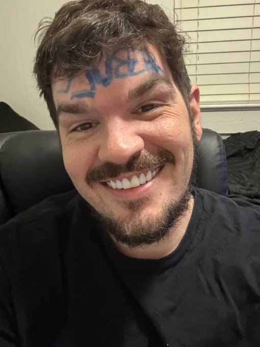The image features a man with a beard, wearing a black shirt, sitting down and smiling for the camera. There are two comments below the photo that read "Do you know him? comment bellow $BULL" and "focus on what is in the image". The main subject of the image seems to be the man's facial expression and his connection with the post.