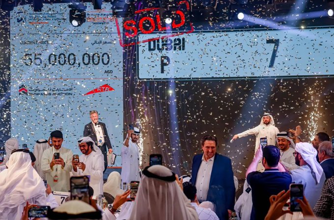 An auction event in Dubai shows a car selling for 55,000,000 AED (marked 'SOLD') with confetti falling, an auctioneer in the center, and attendees in traditional Emirati dress taking photos.