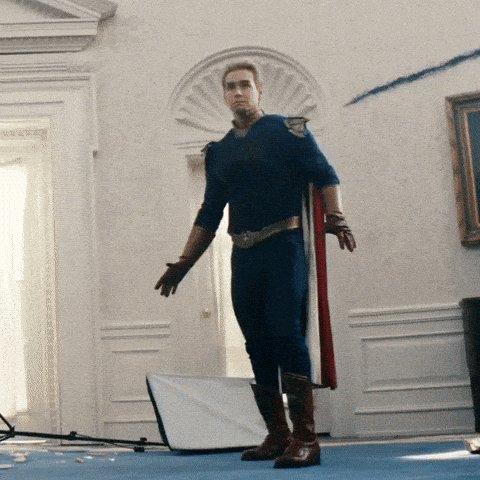 The image features a man dressed as Superman, standing in front of a white door with his arms outstretched. He has a cape and boots on, giving him the appearance of a superhero. The caption "When the bear gets you and suddenly you're mortal again" is related to the scene, suggesting that the man's costume represents the character's transformation from a powerful protector to a vulnerable human being when faced with danger or adversity.