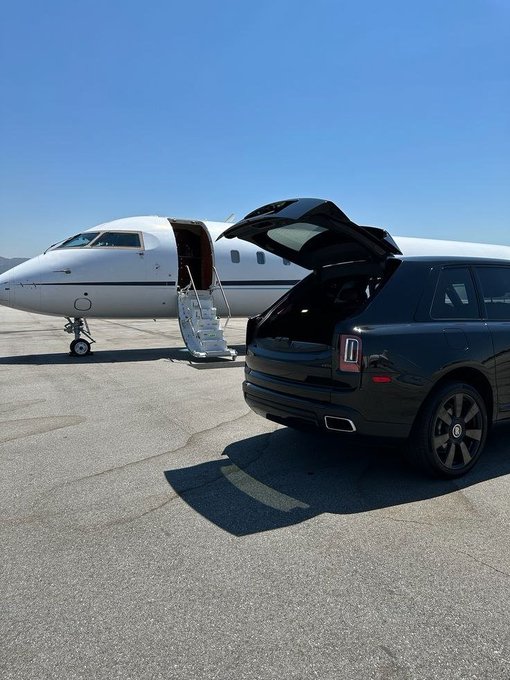The image features a black car parked next to an airplane, with its trunk open. The plane appears to be a private jet, suggesting that the car might belong to someone who has recently arrived at their destination or is preparing for departure. The post includes text such as "big weekend ahead got any plans? @River4fun - @RiverdotInc - $RIVER". This implies that there could be some upcoming events or activities related to the private jet, possibly involving travel or transportation of goods and people.