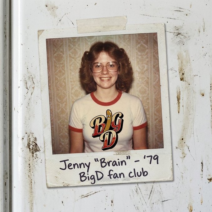 A vintage polaroid photo captioned 'Jenny "Brain" - '79, BigD fan club' showing a smiling young woman wearing glasses and a white ringer t-shirt with a 'Big D' logo.