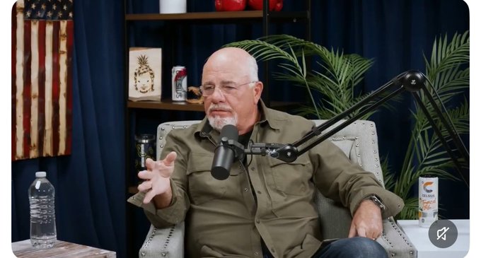 A bald man with a gray goatee wearing an olive green shirt speaks into a microphone on a boom arm during a podcast recording, gesturing with his hand. The background features a rustic American flag decoration, a wooden shelf with a pineapple ornament, a Gatorade bottle, a tropical plant, and a can of Whataburger drink.