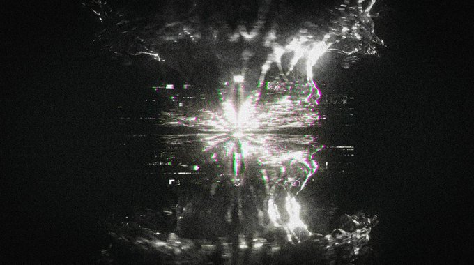 The image shows a black and white photograph of a large, glowing object that appears to be a star or a light source. The object is positioned centrally within the frame, drawing attention as the main focus of the photo. The background is dark, which contrasts with the bright, luminous element in the center of the image. The overall composition creates an intriguing and captivating visual effect.