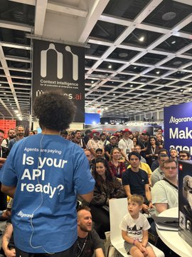 A crowded convention hall scene featuring a person wearing a blue shirt reading 'Nigeria is paying. Is your API ready?' from the Algorand booth, under a sign for 'Marlabs'.