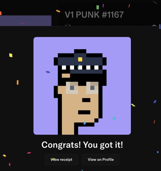 The image shows an email or message with a cartoon character, possibly a personified robot, wearing a hat and glasses. The text in the image congratulates the user for their decision to choose the v2 Punk over the original V1 Punk. The caption also mentions that the original V1 Punk was created by Jalilwah Dat and is now being fixed with the creation of the v2 Punk.