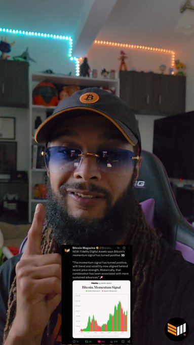 A bearded man wearing a black cap and blue glasses speaks to the camera while pointing upward, with a Bitcoin Magazine tweet overlay discussing a 'momentum signal' in a price chart.