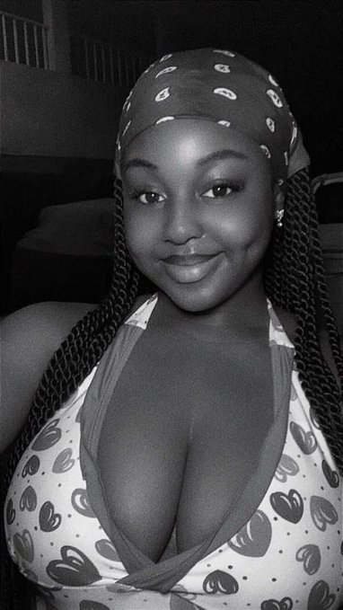 A black-and-white selfie of a young woman wearing a patterned bandana and a heart-printed bikini top, smiling softly at the camera, paired with a cheerful "Gm cT" good morning message to the crypto community.