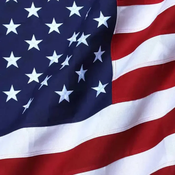 An American flag waves prominently in the image, symbolizing the U.S. government's involvement in moving over $1 billion in Bitcoin linked to the Bitfinex hack. This visual reinforces the post's alert about significant crypto movements, including a 12,267 BTC transfer by a government-linked wallet and additional transactions sent to Coinbase Prime.