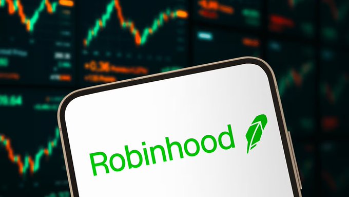 A smartphone displaying the green Robinhood logo against a backdrop of financial trading charts with red and green candlestick patterns.