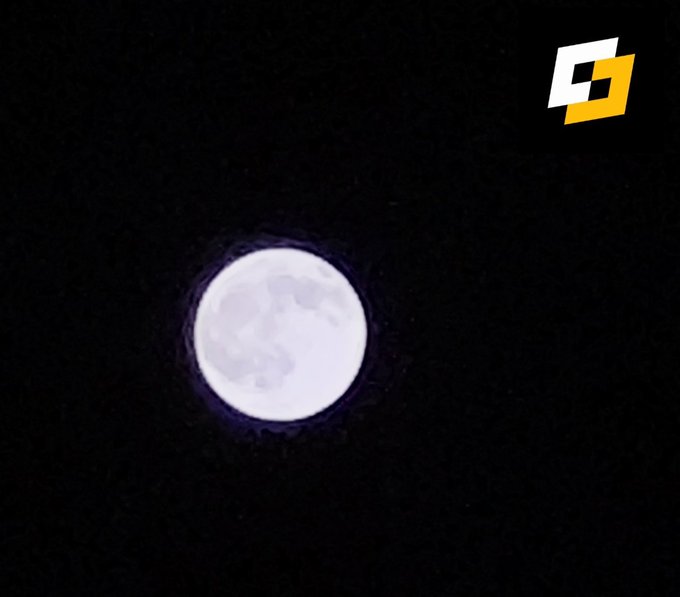 A full moon glows in the night sky, accompanied by a small orange and white logo in the upper right corner.