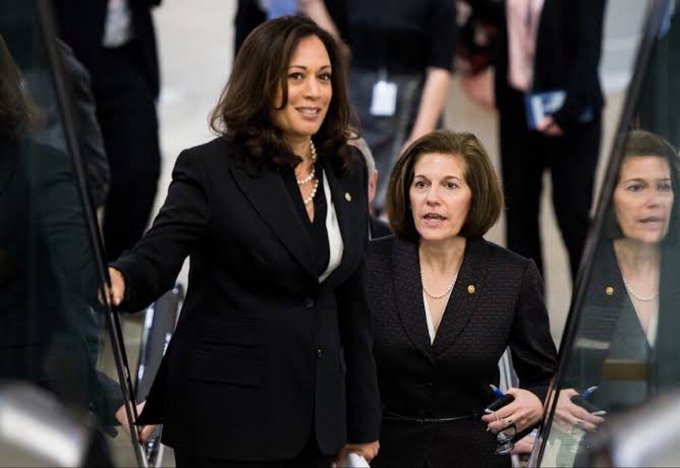 I can see two women in professional attire descending what appears to be stairs or an escalator in a government building setting. The woman on the left has shoulder-length dark hair and wears a black blazer with a pearl necklace, while the woman on the right has shorter brown hair and also wears a black blazer with pearls. 

However, I'm not able to confirm the identities of the individuals in the image based on their appearance, and I can't verify whether this relates to the post's claim about Senator Masto announcing support for the Crypto Clarity Act. If you could confirm who is pictured, I'd be happy to help craft a caption connecting the image to that announcement.