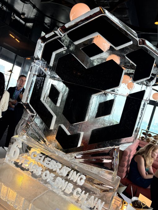 An ice sculpture celebrating 'BNB CHAIN' featuring the BNB logo and the text '6 YEARS OF BNB CHAIN CELEBRATING'.