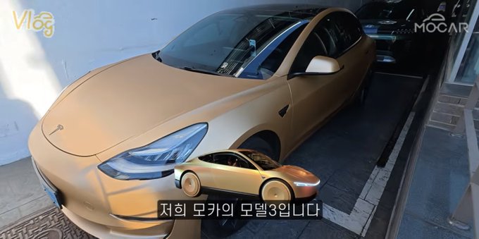 A thumbnail showing a matte gold Tesla Model 3 with a smaller image of a gold sports car overlaid, featuring the text 'Vlog', 'MOCAR', and Korean text '저희 모카의 모델3입니다'.