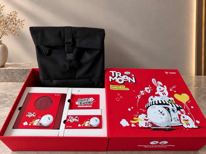 A red promotional gift box for 'TROOM TROOM Happy Mid-Autumn' featuring cute cartoon bunnies and a mooncake, displayed next to its black carrying bag.