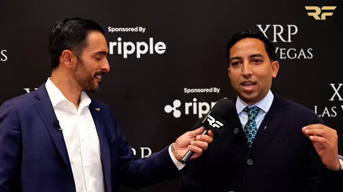 The image features two men dressed in suits, one wearing a blue suit and the other wearing a black suit, standing against a black background with white text. The man in the blue suit appears to be speaking into a microphone while the man in the black suit is listening attentively. The backdrop includes the words "Crypto Winter" and "Evernorthxrp", suggesting that they are discussing the current state of cryptocurrency adoption and regulation within the financial industry.