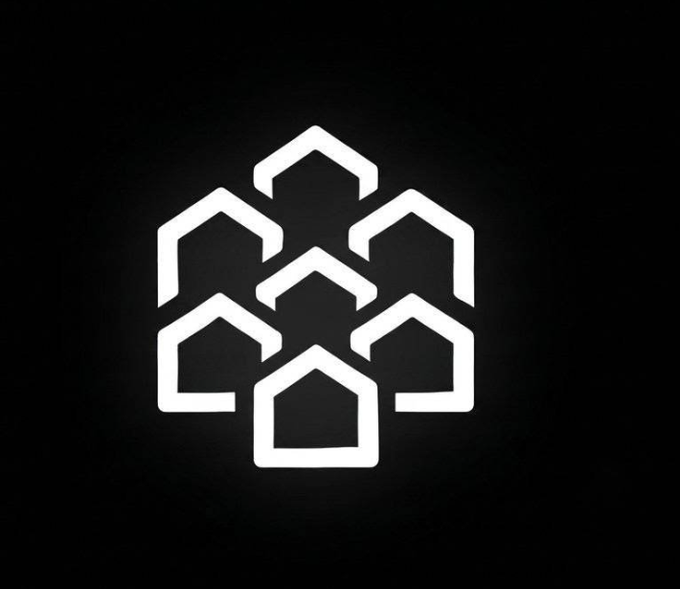 A white geometric logo featuring six interlocking house outlines arranged in a hexagonal pattern against a black background, symbolizing the tokenization of real estate assets referenced in the announcement about Pineapple Financial bringing $1 billion in real estate mortgages onto the Injective blockchain.