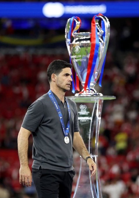 The image features a man wearing a grey shirt, standing near a trophy with a red ribbon around it. The trophy appears to be a soccer cup or trophy, which suggests that he might have won an award related to soccer. The caption of the image reads "gather round for your sunday sermon vanity metrics are a sin follower count is false god bot farms are the devil @wallchain is the only truth Arsenal fans already suffered enough this week don' t let your campaign be next.

The man's position in front of the trophy and his attire, including a grey shirt, further emphasize that he has achieved something significant or accomplished an important milestone. The caption serves as a reminder to the viewers about the importance of recognizing and celebrating achievements, whether they are related to sports or other fields.