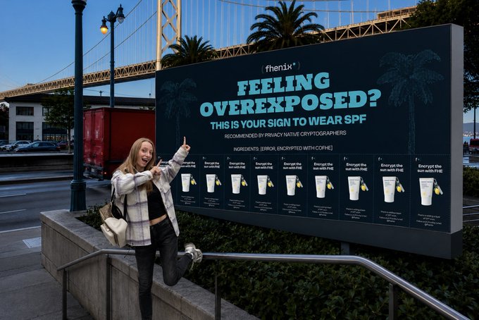 A woman poses and points excitedly at a billboard for '{henix}' reading 'FEELING OVEREXPOSED? THIS IS YOUR SIGN TO WEAR SPF', recommended by privacy native cryptographers with ingredients encrypted with cophe.