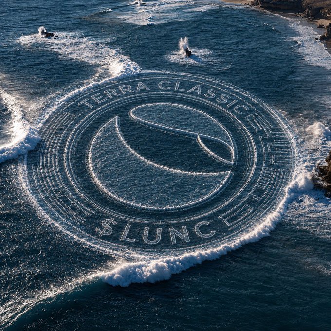 An aerial view of ocean waves creating a large circular pattern labeled 'TERRA CLASSIC' and '$LUNC' with a crescent logo in the center.