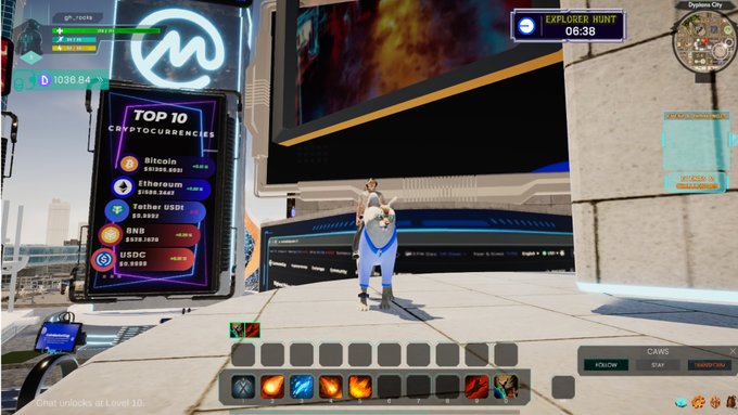 The image shows a man standing next to a large screen, possibly at a gaming convention or event. The screen displays information about the current market conditions for cryptocurrencies. The man appears to be wearing a blue shirt with a white logo.