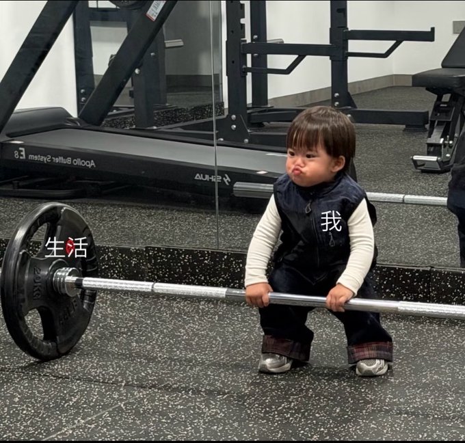 A determined toddler struggles to lift a heavy barbell in a gym, with Chinese characters "我" (me) on his vest and "生活" (life) on the weight plate, symbolizing his battle against life's burdens. The image humorously mirrors the post's theme of feeling overwhelmed by life and struggling to compete in crypto trading, while the barbell represents the heavy weight of finances and Binance's 1WU alpha grinding grind.