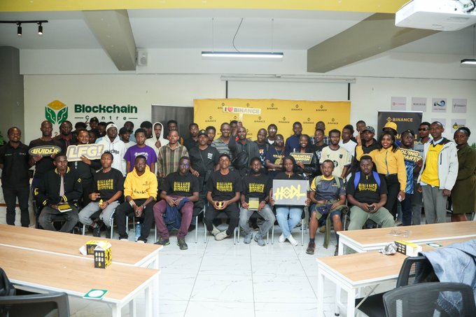 Attendees gather at a Binance Learning Labs event held at the Blockchain Centre in Nairobi, Kenya, wearing branded Binance apparel and posing with signs like "BUIDL," "LEG," and "HODL." The group photo captures the community of participants who joined the educational session covering TradFi and bStocks for beginners on Binance.