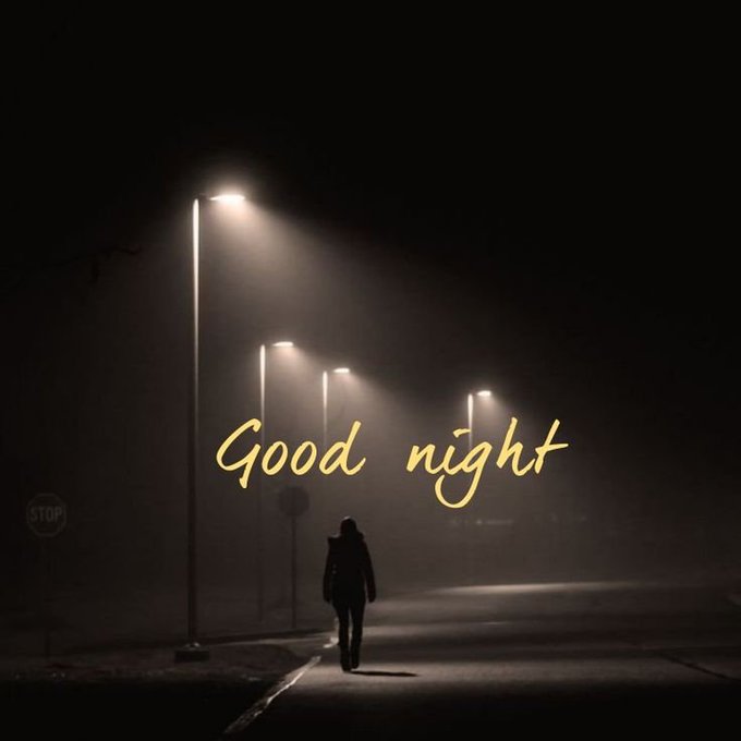 A moody nighttime scene showing a lone figure walking down a foggy street illuminated by streetlights, with "Good night" written in elegant yellow script across the image.