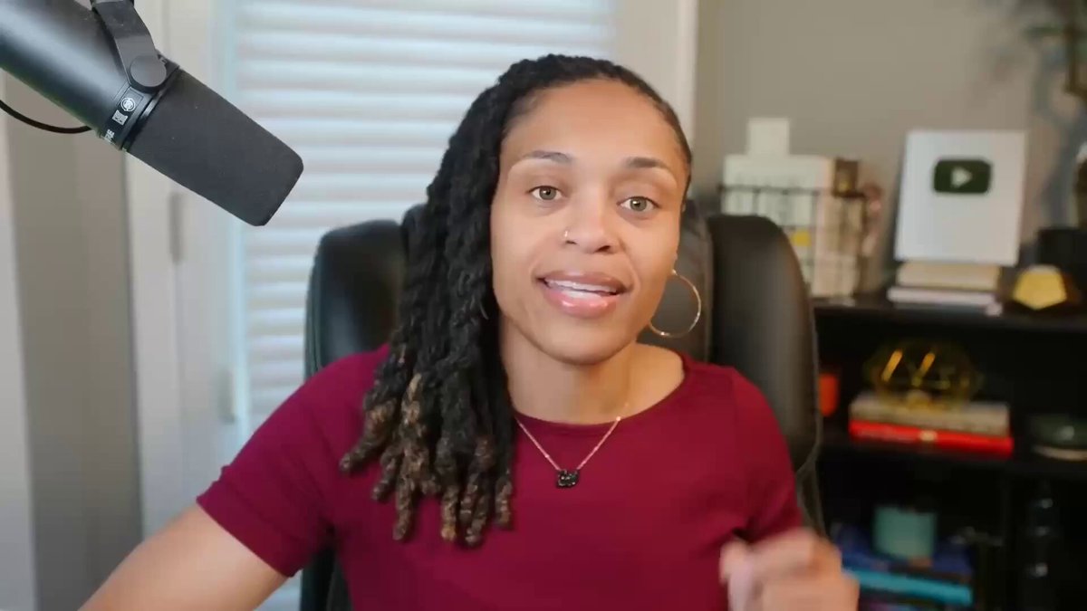 The image features a woman sitting behind a microphone, smiling at the camera while wearing a red shirt. The background of the image shows a bookshelf filled with various books, suggesting that she might be discussing financial topics or sharing insights related to investing in long-term infrastructure projects. The presence of multiple books indicates that this could be an educational or informative session rather than just a casual conversation.