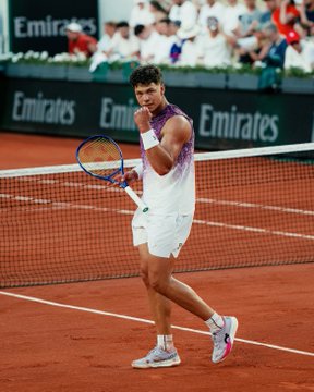A tennis player celebrates in front of "Emirates" banners on a clay court, illustrating the sport where a Polymarket trader achieved a $256K swing on tennis markets.