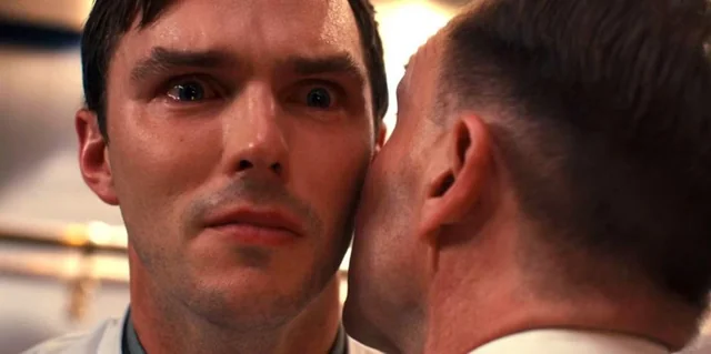 A close-up still from a film showing a wide-eyed man staring intensely as another man whispers directly into his ear, visually capturing the feeling of receiving shocking or disturbing news—mirroring the post's sentiment that Bitcoin's $40K level has shifted from a confident prediction to a hopeful wish for crypto holders.