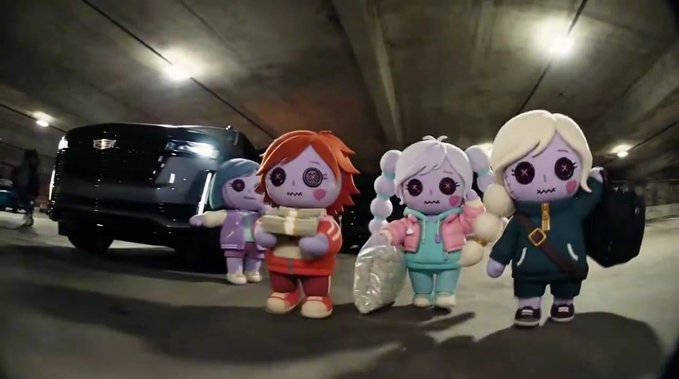 Four animated, plush-like characters with button eyes stand in a parking garage, one holding a stack of cash and another carrying a bag, with a black Cadillac behind them.