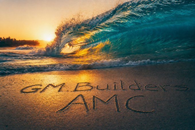 A vibrant sunset wave crashes on a beach with the text "GM.Builders AMC" written in the sand.