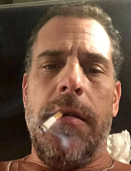 A close-up selfie of a middle-aged man with a beard, smoking a cigarette with a slightly surprised expression.