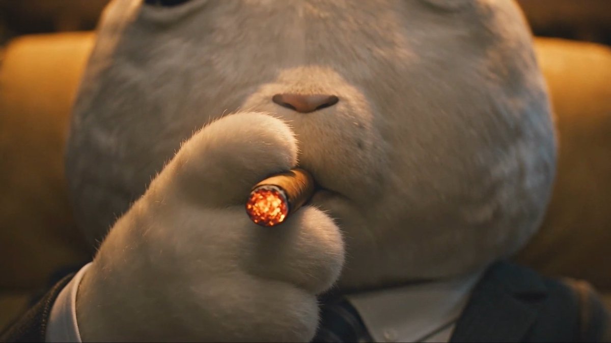An animated gray cat character holding a lit cigar in its paw, wearing a suit and tie.