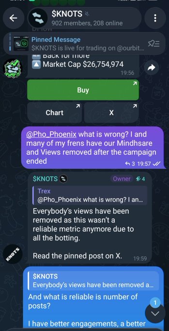 The image shows a Telegram chat for the $KNOTS token group, where a user named Pho_Phoenix questions the team about removed views and engagement metrics after a campaign, with messages discussing view removals, "reliable metric," and bot activity, alongside market cap data showing $26,754,974—directly illustrating the user's complaint about the campaign rule changes and disqualifications referenced in the accompanying post.