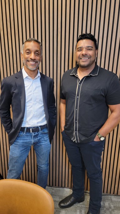 Two men pose smiling in front of a wood-slatted wall, with the man on the left in a blazer and the man on the right in a black short-sleeved shirt. The setting matches the post's context of a post-interview photo with Amar Kuchinad, CEO of Copper, after discussing his background in traditional finance and crypto custody for institutions.