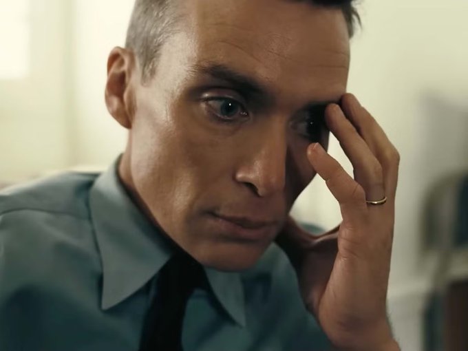A man with a worried expression presses his hand to his forehead while wearing a wedding ring, suggesting financial stress or anxiety. The "BankChain" context connects to themes of banking concerns or financial uncertainty depicted in the image.