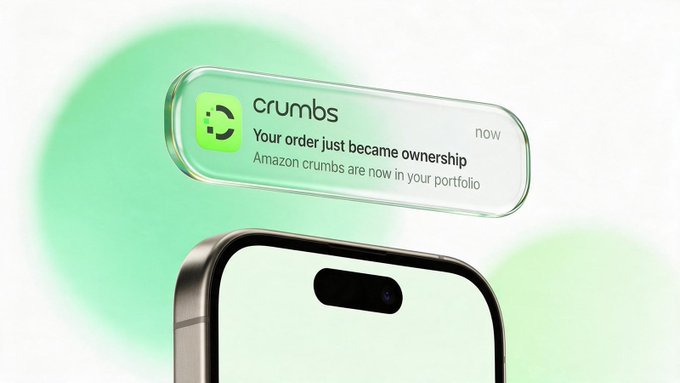 A 3D rendering of a smartphone displaying a notification from 'crumbs' that reads 'Your order just became ownership - Amazon crumbs are now in your portfolio'.