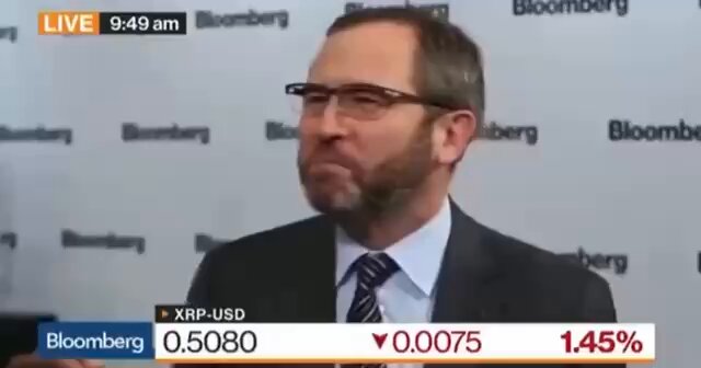 The image shows a man wearing glasses, standing against a white background with a large screen displaying the text "CRAZY: Ripple'S Brad Garlinghouse: 'What we're doing... is taking over SWIFT'. The scale is TRILLIONS upon TRILLIONS." and "XRP is KING of Crypto!!!". This image seems to be related to a post on social media, possibly discussing Ripple's impact or the rise of cryptocurrency.

The man in the picture appears to be wearing a suit and tie, which suggests that he might be a professional or attending an event where formal attire is required. The content displayed on the screen includes text about Ripple, a cryptocurrency, and its potential influence on traditional financial systems.