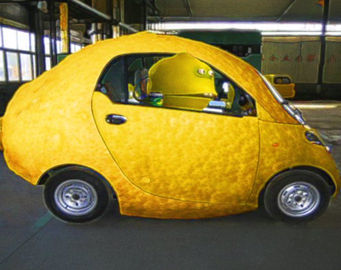 A small compact car is covered entirely in a fuzzy, yellow, lemon-like rind in what appears to be a garage or warehouse setting.